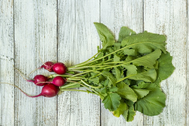 Bunch of red radish fromgarden bed on a rural table