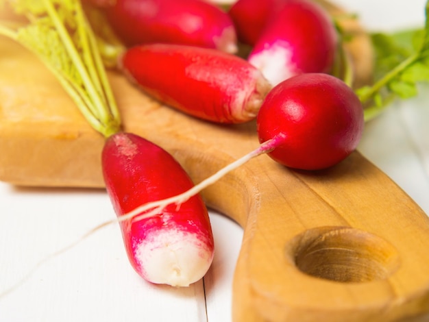 A bunch of red radishes on a wooden background