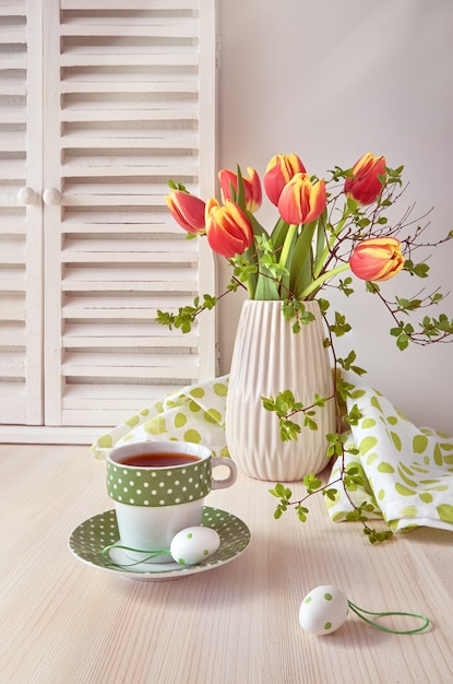 Bunch of red tulips, espresso in green cup with white dots and cookies
