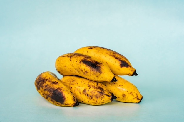 Bunch of ripe bananas on blue background. Close up stock photo.