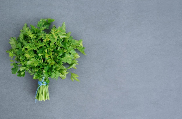 Bunch of ripe parsley on dark and moody textured background Above view