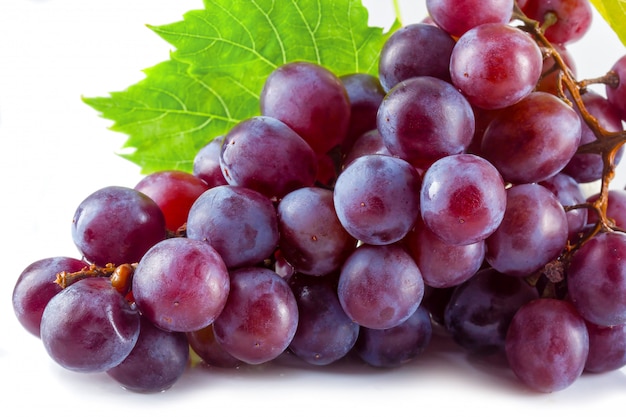 Bunch of ripe red grapes with leaves isolated