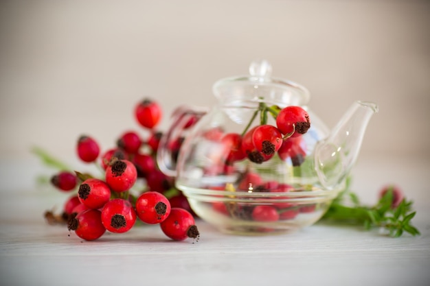 a bunch of ripe red rose hips on a wooden table