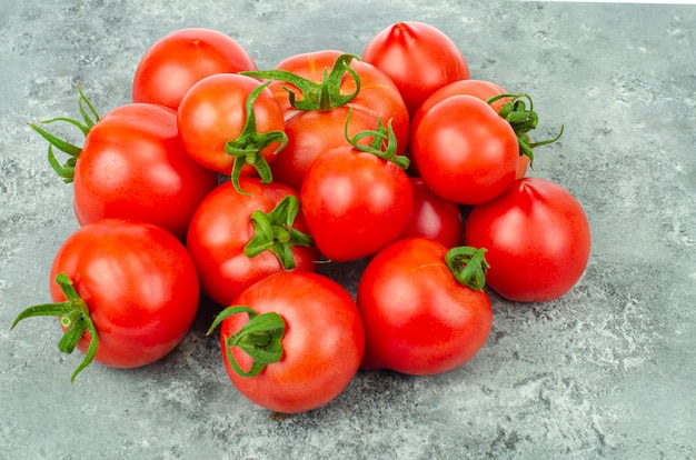 Bunch of ripe tomatoes on blue-gray background. Studio Photo.