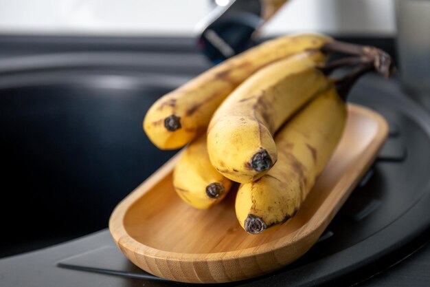 Foto un casco di banane gialle mature in cucina vicino al lavello