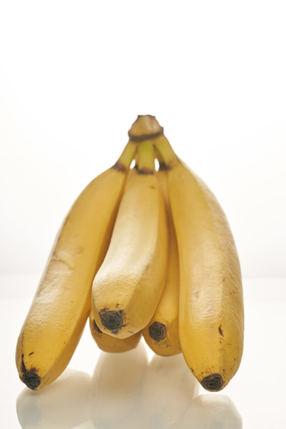 Mazzo di banane gialle mature su fondo bianco