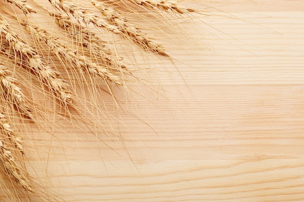 Photo bunch of rye ears on wooden