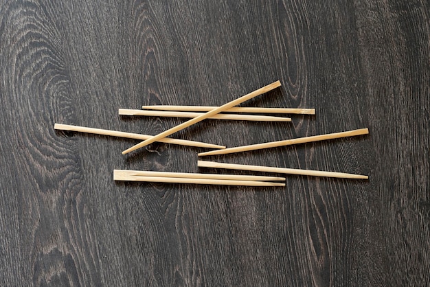 Photo a bunch of simple wooden chopsticks flat lay isolated on the table