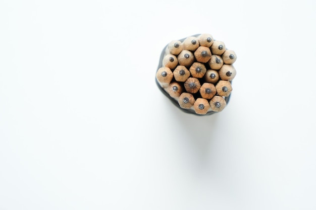 Bunch of simple wooden pencils from above on white background