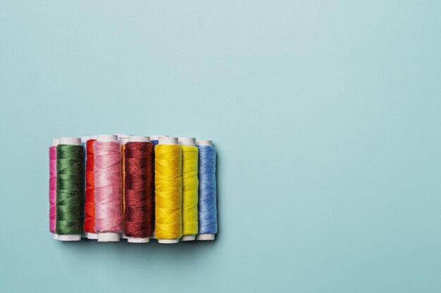 A bunch of spools of colored thread on a smooth