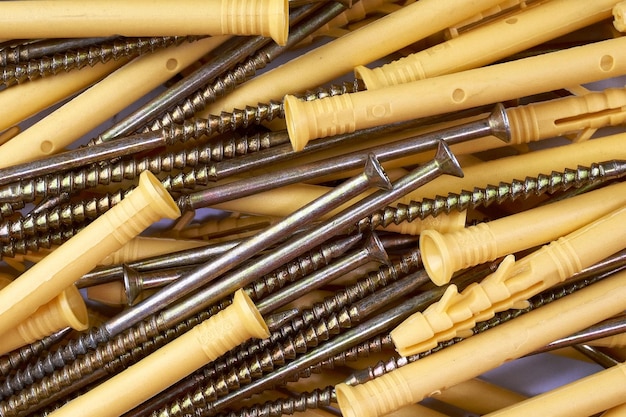 Bunch of tapping construction screws with plastic dowels for fixture Selective focus Closeup