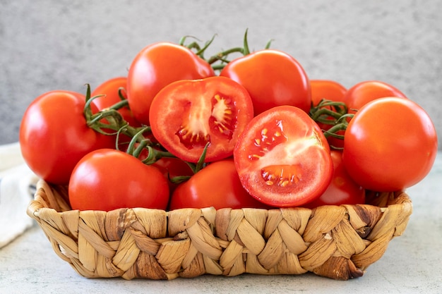 Photo bunch tomatoes fresh tomatoes in basket on stone floor organic food close up