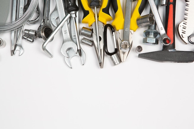 A bunch of tools are laying on a white surface.