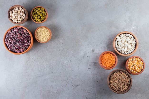 Bunch of uncooked lentils, beans and rice on stone background. 