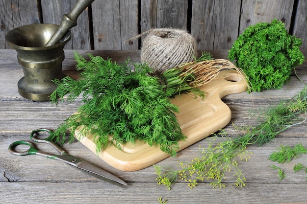 Foto bunch van dill op een snijplank op een grijze houten tafel