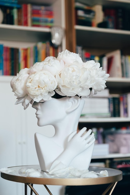 Photo bunch of white peonies in human head vase