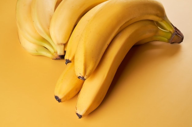 黄色で分離されたバナナ全体の束