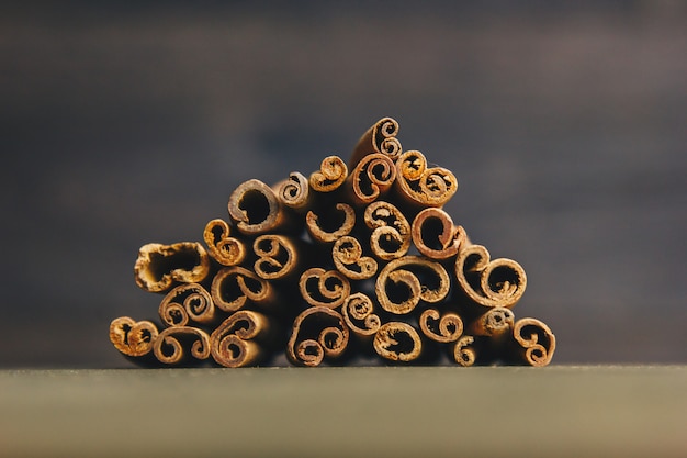 A bunch of whole sticks of fragrant cinnamon on a wooden rural table. copyspace. composition of seasoning and slide flavoring aromatic spice. close-up. front view