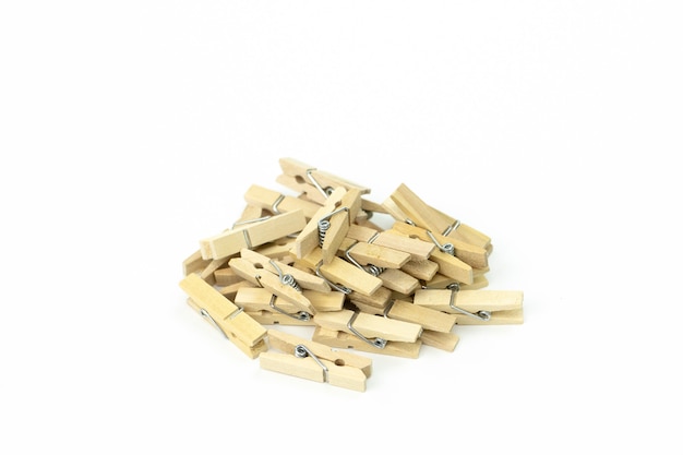 Bunch of wooden clothespins piled up in mess on white surface