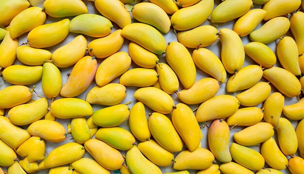 A bunch of yellow mangoes are on a table.