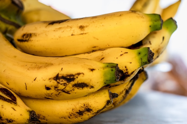 選択的な焦点と黄色の熟したバナナの束をクローズアップ
