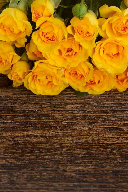 Bunch of yellow roses border on wood