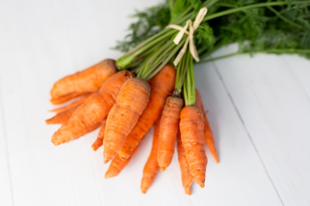 a bunch of young carrots on a white background. carrot with leaves