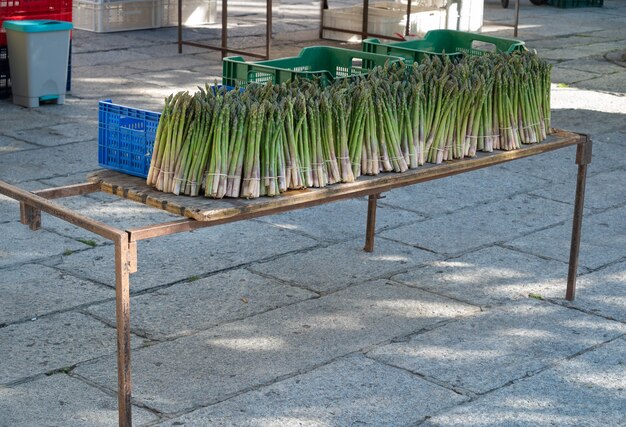 Mazzi di asparagi in vendita su una bancarella di strada in un mercato delle pulci