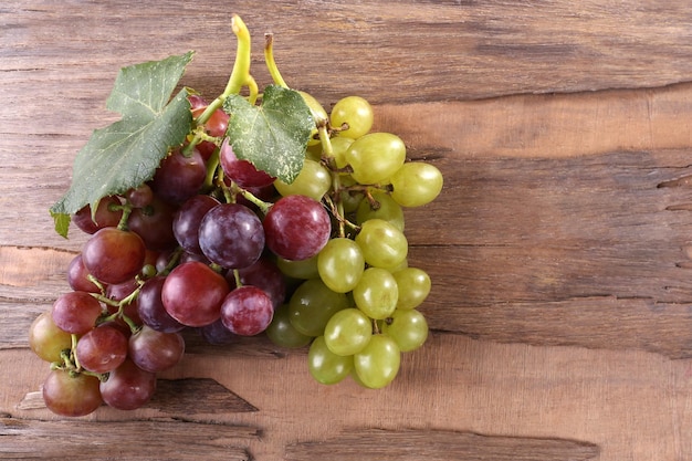 Bunches of different kinds of grapes on wooden background