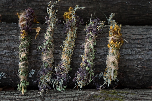 Foto mazzi di fiori secchi ed erbe aromatiche su fondo di legno