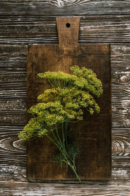 Bunches of fresh green dill greens on a brown wooden board 1