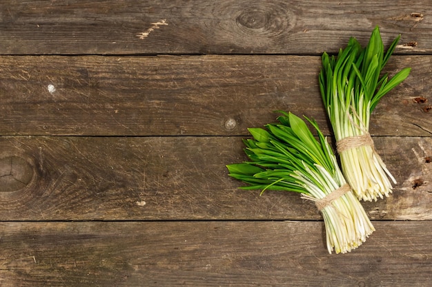 Bunches of fresh harvest of spring ramson wild leek Fragrant spicy leaves on vintage wooden table