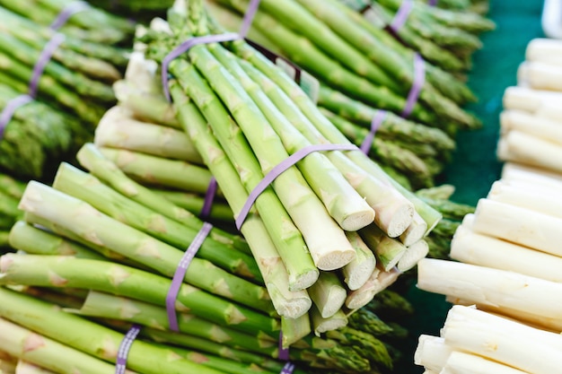 Bunches of fresh raw green organic asparagus vegetables for sale at farmers market. Vegan food concept. Stock photo green Asparagus Close up.