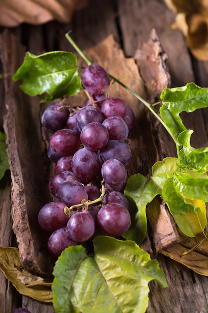 Bunches of fresh ripe red grapes on a wooden textural background