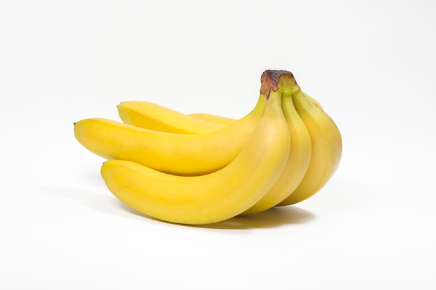 Bunches of yellow bananas lie on a white background isolated