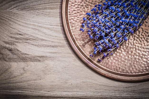 Bundle of dry scented lavender copper tray on wooden board healthcare concept