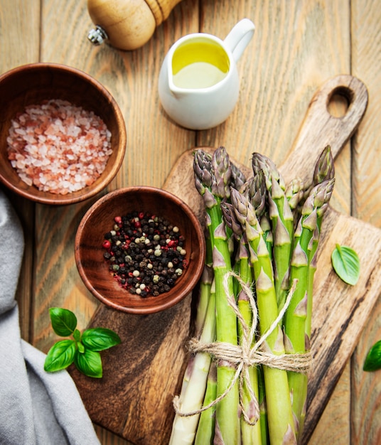 Bundle of fresh green asparagus on a rustic wooden table , top view