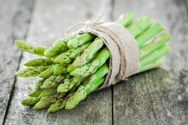 Bundle of of ripe organic asparagus on a wooden background