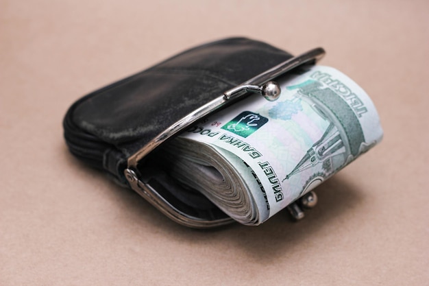 Photo a bundle of russian banknotes of 1000 rubles in an old black wallet