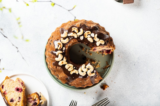 Bundt cake met noten en chocolade op witte achtergrond. Bovenaanzicht van taart. Feestelijke taart. Nieuwjaarscake met chocolade. Kerst dessert.