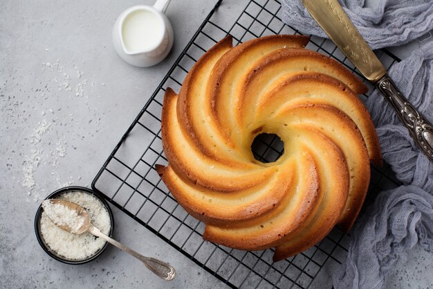 Bundt cake met suikerglans en kokos op donkergrijze oude betonnen ondergrond. Selectieve aandacht.