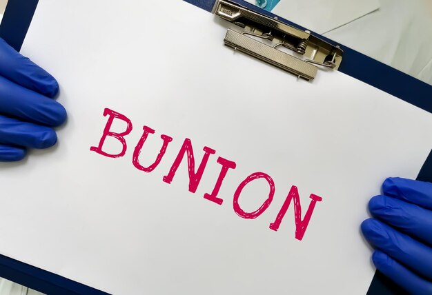 의사 손에 화이트 보드에 의료 개념으로 Bunion 의학 용어 단어