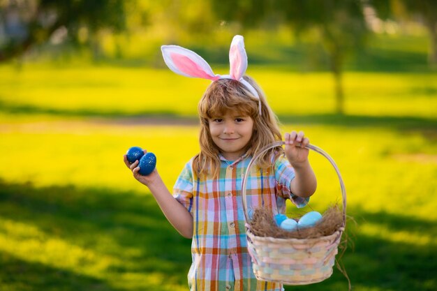 Bunny boy kids boy in bunny oren jagen op paaseieren buiten kind met Pasen in park easter egg