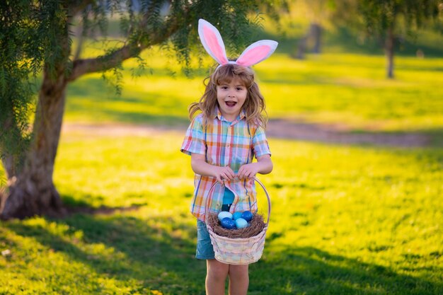 Bunny child child boy hunting easter eggs cute kid in rabbit costume with bunny ears having easter i