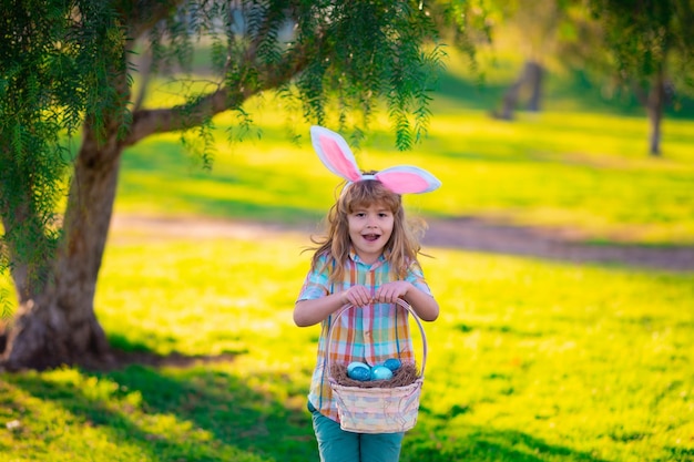 Bunny child Easter bunny children Kids boy in bunny ears hunting easter eggs in park outdoor