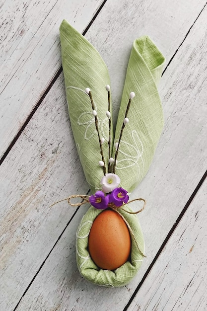 Bunny Ears van groen servet met ei op natuurlijke houten achtergrond om Pasen te vieren