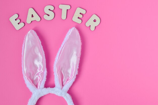 Bunny ears with wooden letters on pink