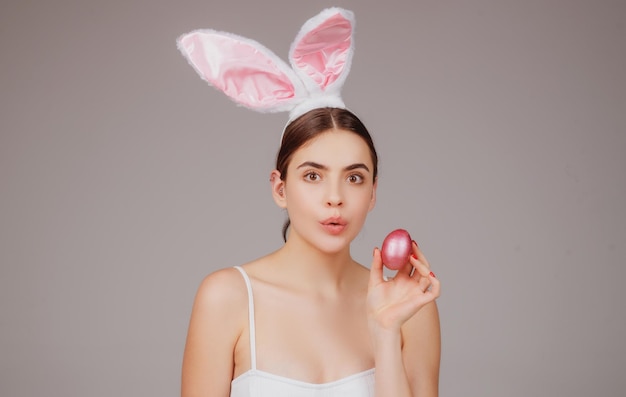 Bunny girl with easter egg Surprised woman in rabbit ears