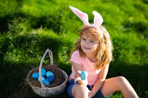 Bunny paaskind kinderen jagen op paaseieren jongen met paaseieren en konijnenoren in de achtertuin pasen h...
