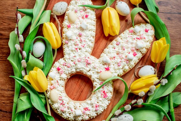 A bunny shaped cookie made with white chocolate eggs and sprinkles.